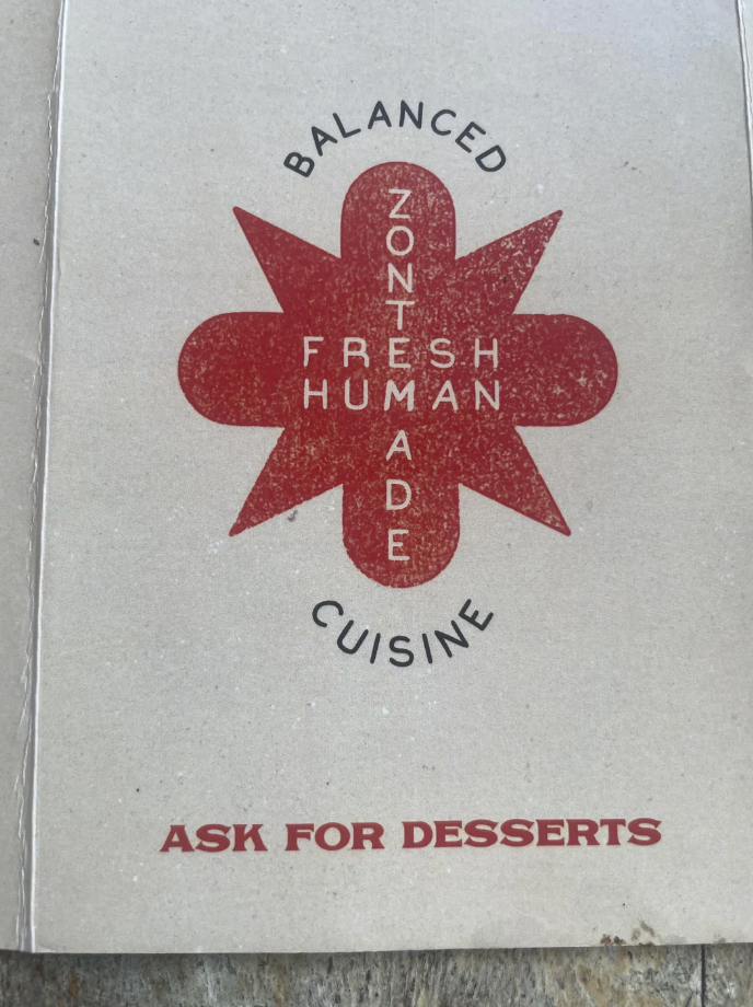 Menu cover with a star shape that says "Balanced, Fresh, Human Made, Cuisine." Text at the bottom reads "Ask for desserts."