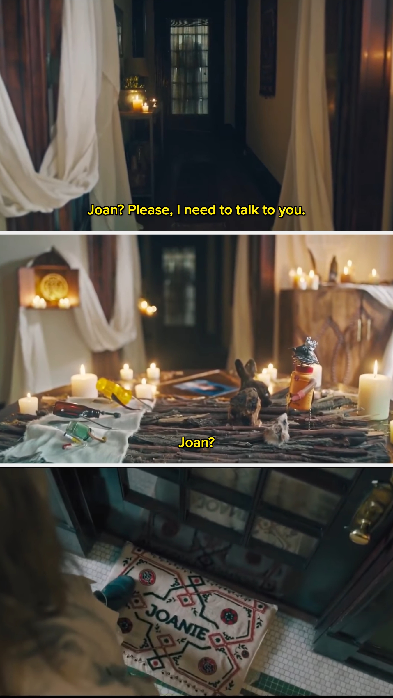 A person approaches a dimly lit room with lit candles on a table. The floor mat reads "Joanie." They call out for Joan
