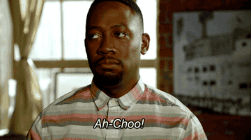 Person sneezes dramatically, shaking their head side to side, with "Ah-Choo!" written underneath the gesture