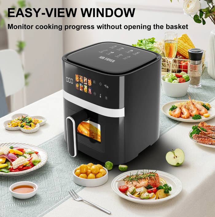 Air fryer connected a eating array with assorted dishes, featuring an easy-view model for monitoring cooking without opening the basket