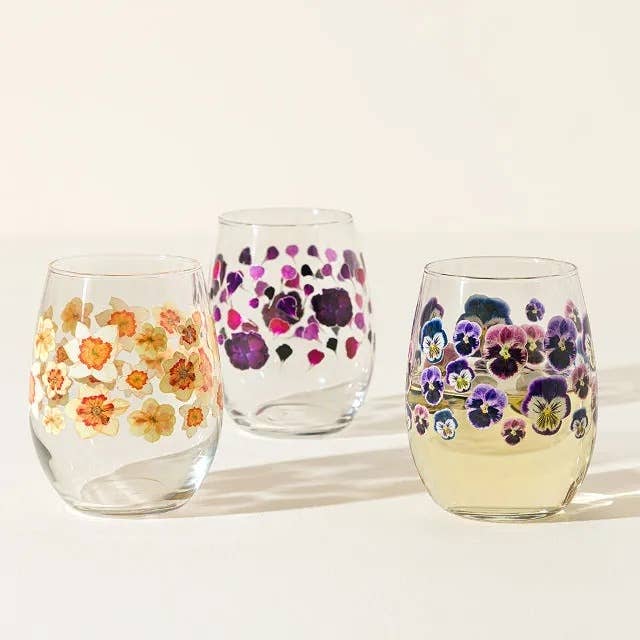 Three glass tumblers decorated with pressed floral designs, featuring various flowers. Perfect for enhancing table settings or gifting