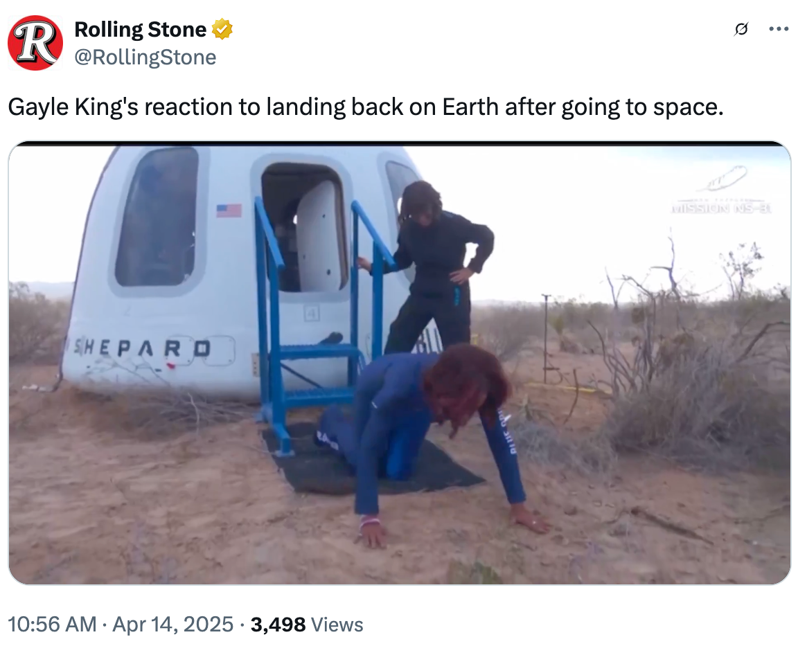 Two people exit a capsule in a desert area. The first person lies on the ground in a space jumpsuit