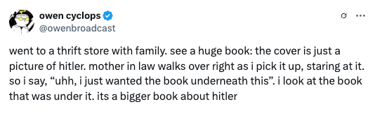 Tweet by Owen Cyclops about finding a large book with Hitler's image at a thrift store, leading to a humorous encounter with his mother-in-law