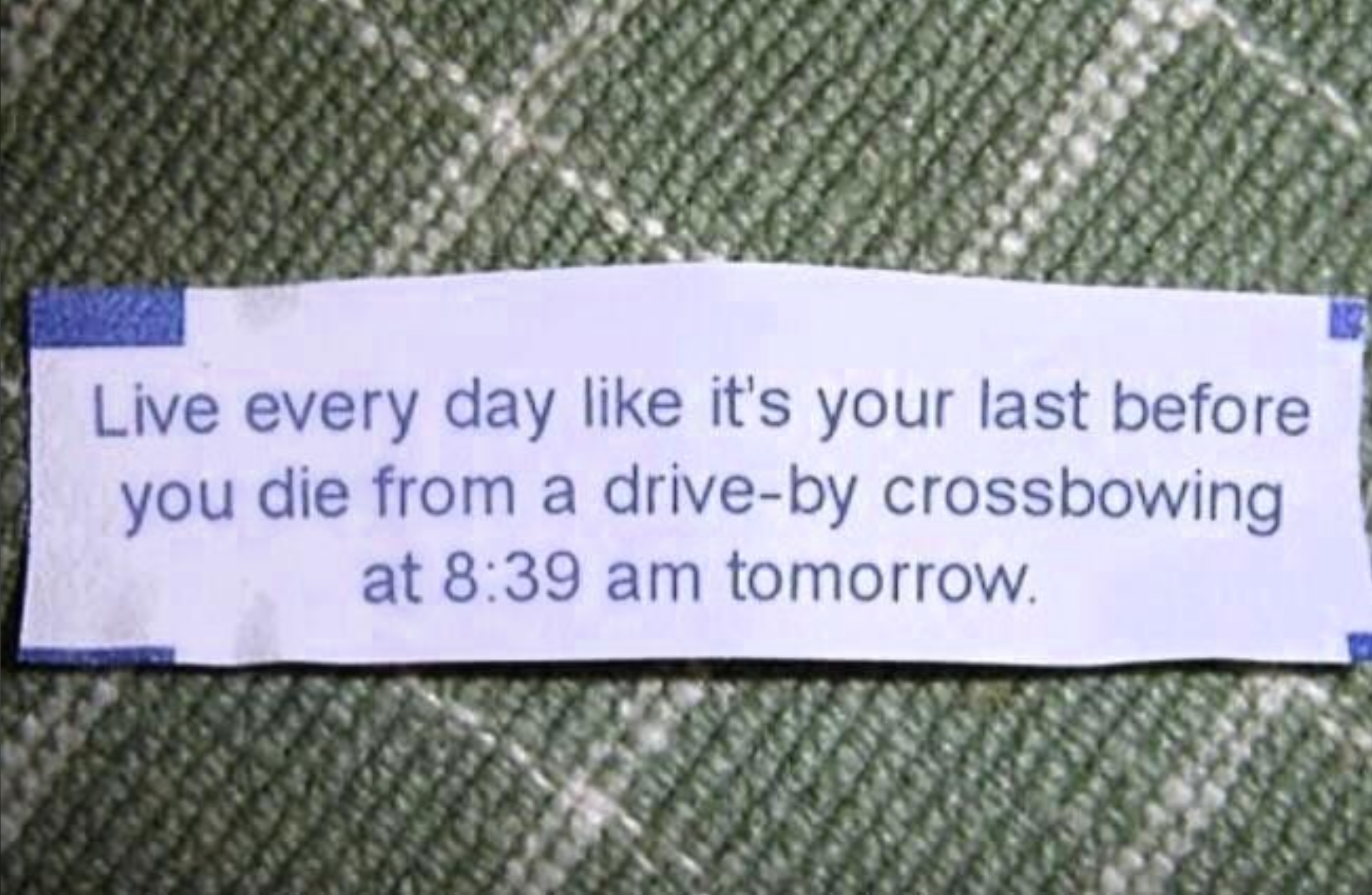 Fortune cookie paper with text: "Live every day like it's your last before you die from a drive-by crossbowing at 8:39 am tomorrow."