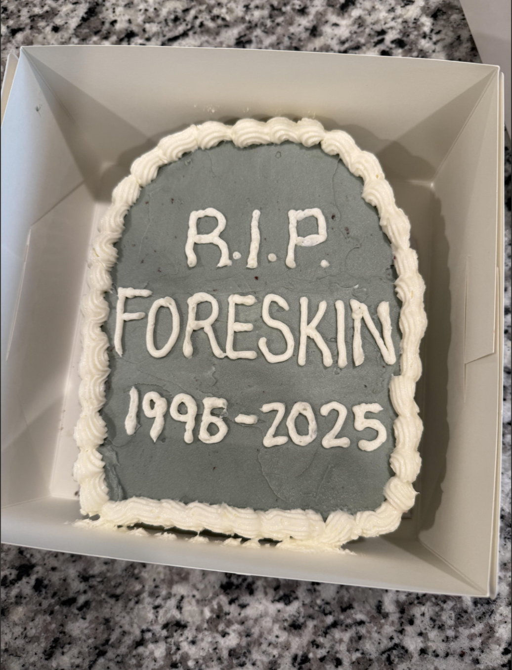 Cake shaped like a gravestone with the text "R.I.P. Foreskin 1995-2025" written on it
