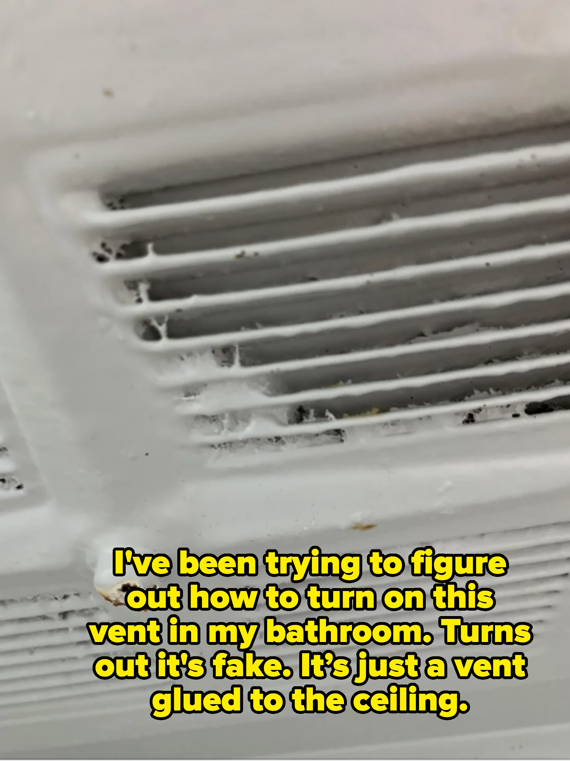 Close-up of a fake dusty ceiling vent captioned "I've been trying to figure out how to turn on this vent in my bathroom. Turns out it's fake. It’s just a vent glued to the ceiling"