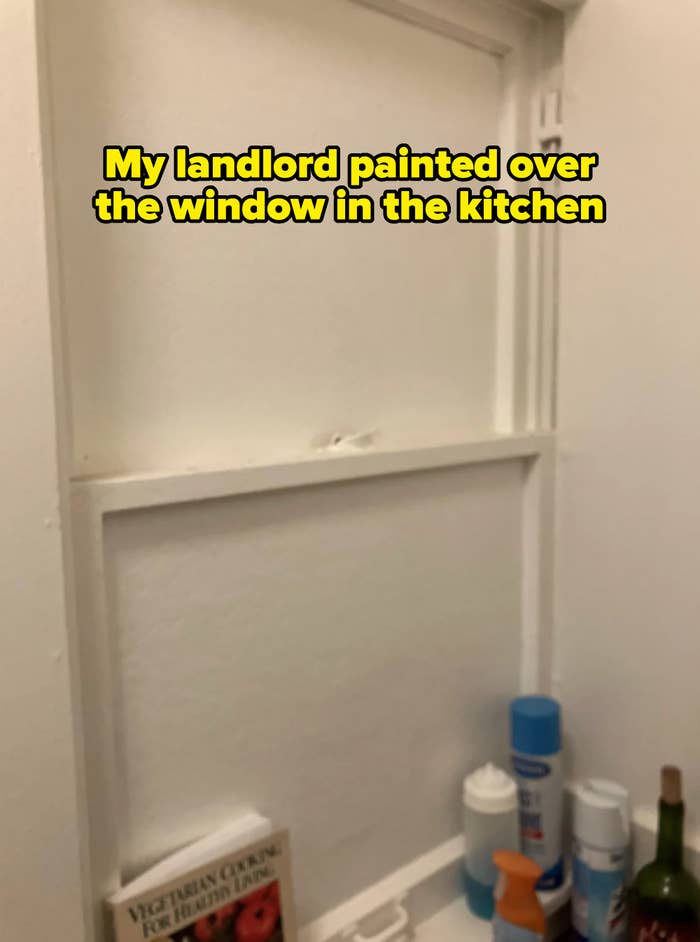 painted-over window with caption about landlord being responsible