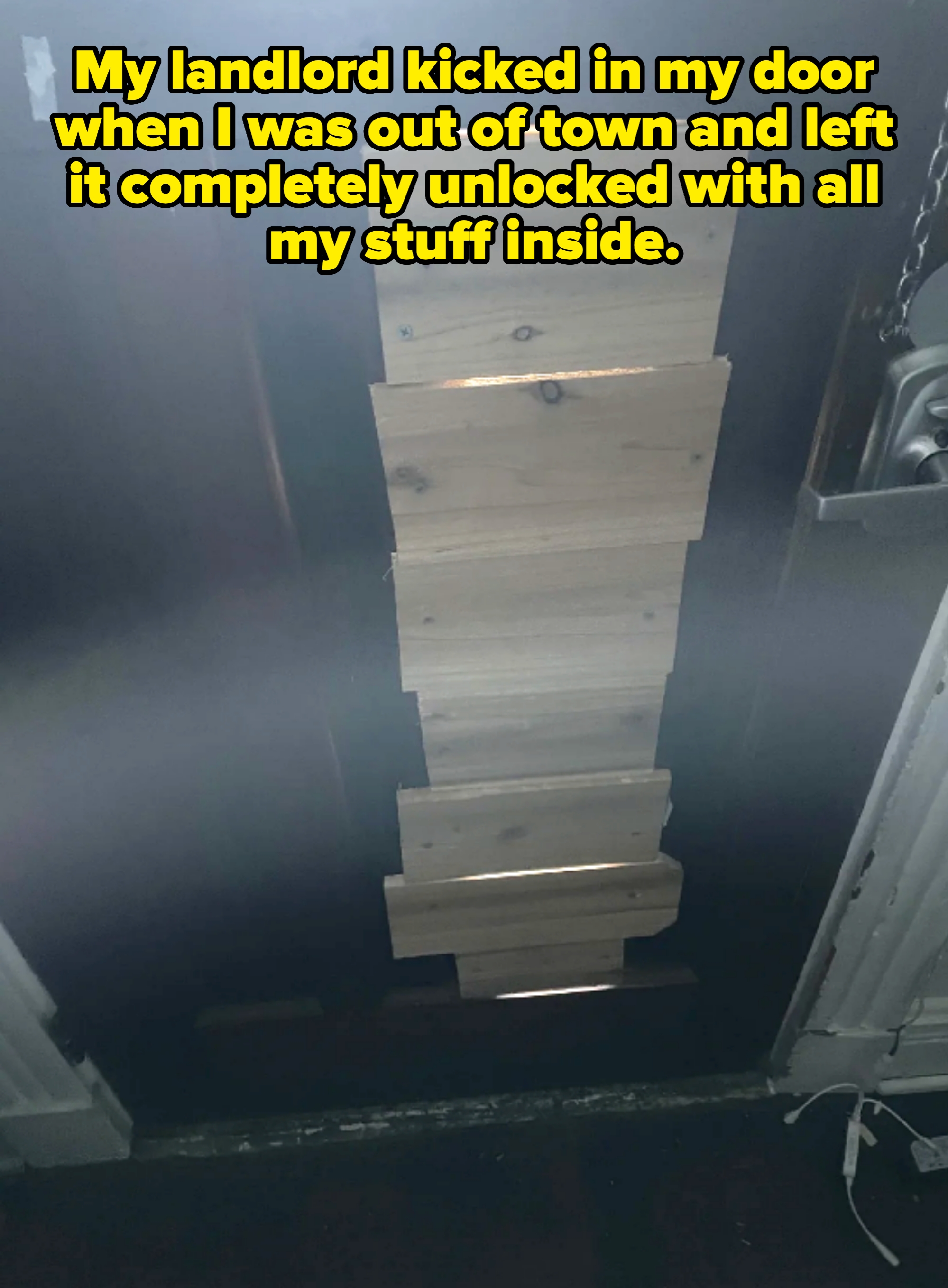 A door with missing panels is patched with several wooden planks. Caption: "My landlord kicked in my door when I was out of town and left it completely unlocked with all my stuff inside"
