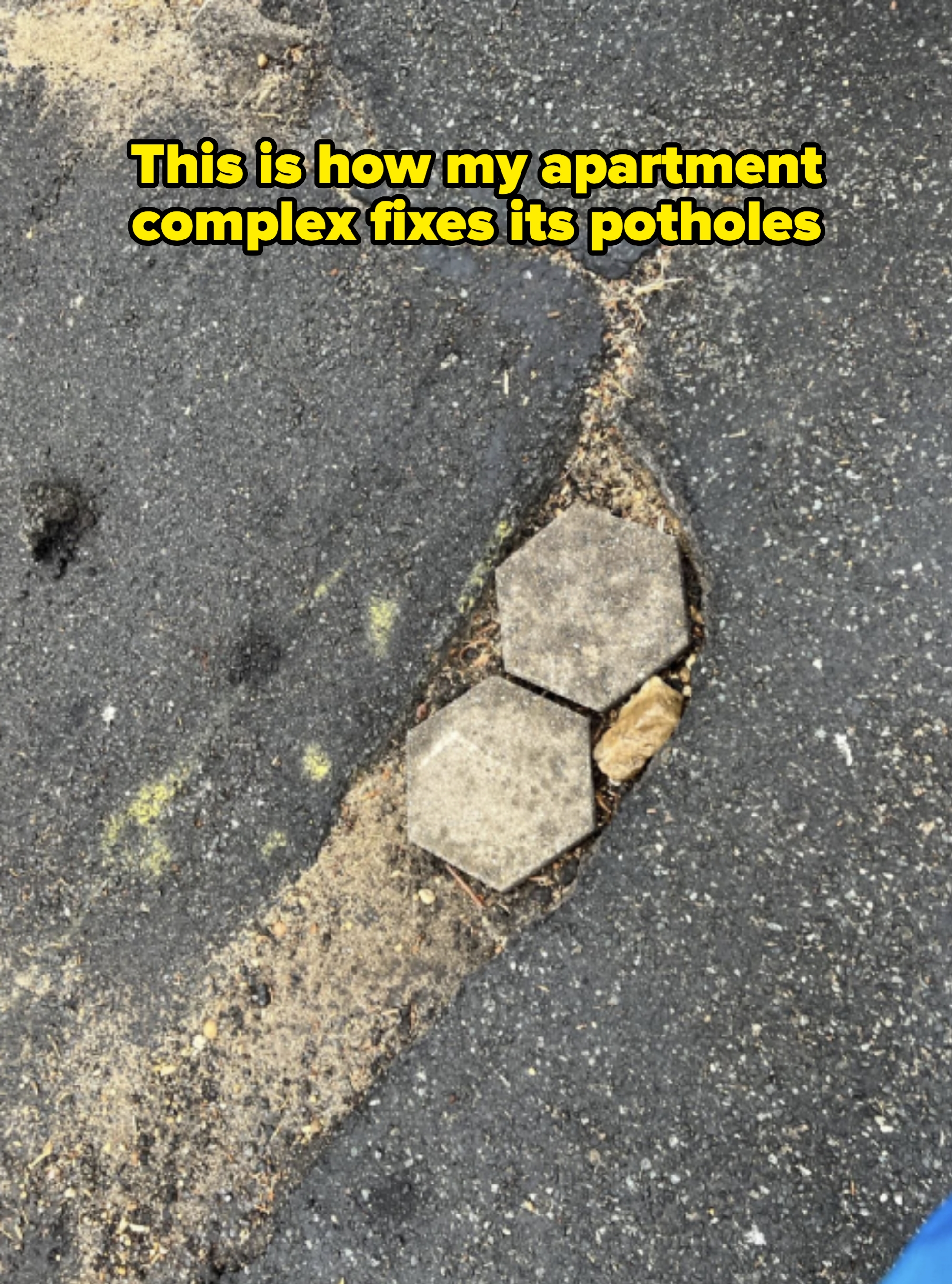 Hexagonal pavers embedded in a cracked asphalt pavement captioned "This is how my apartment complex fixes its potholes"