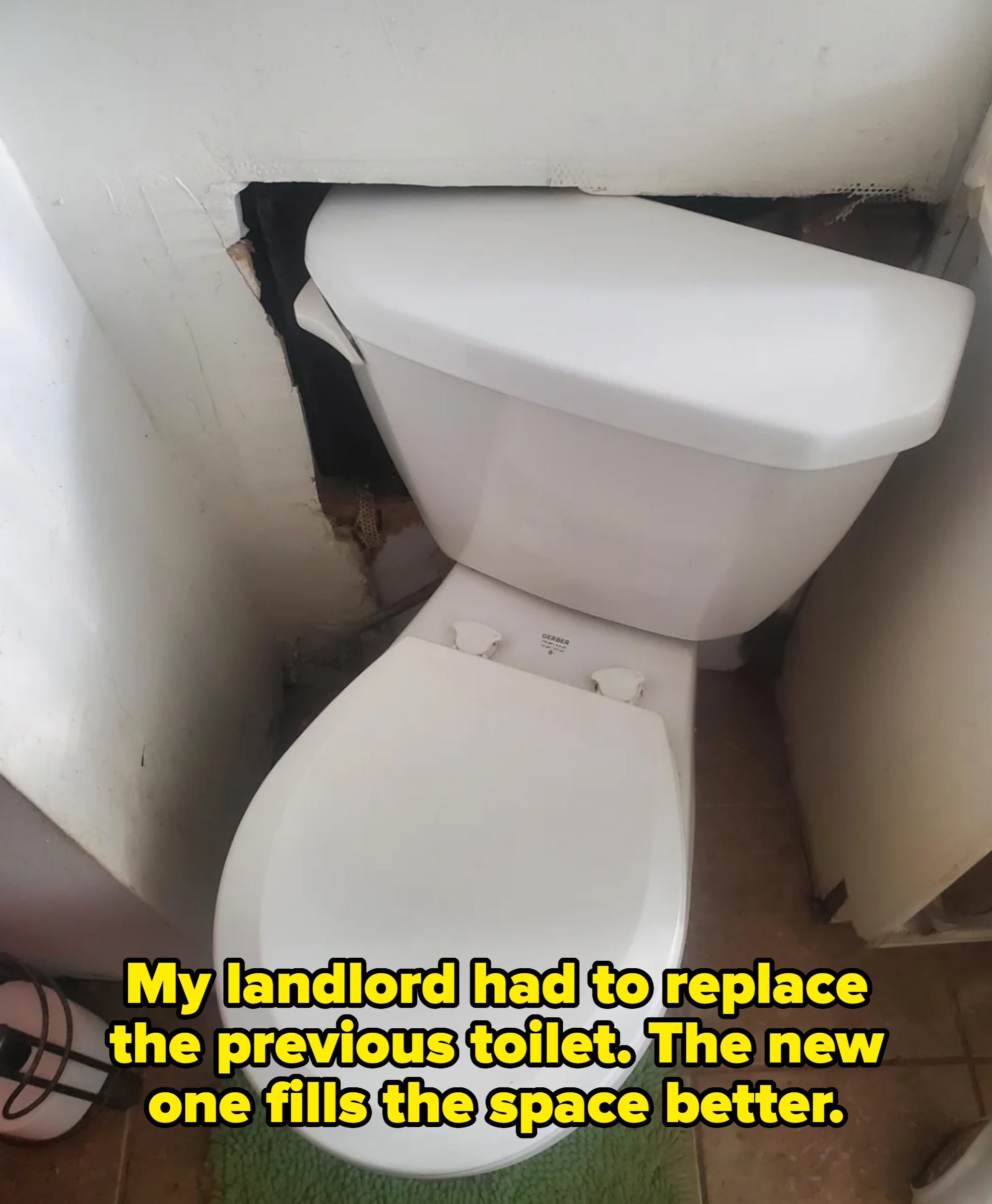 toilet half pushed into the wall at a diagonal with note about it being a replacement from the landlord