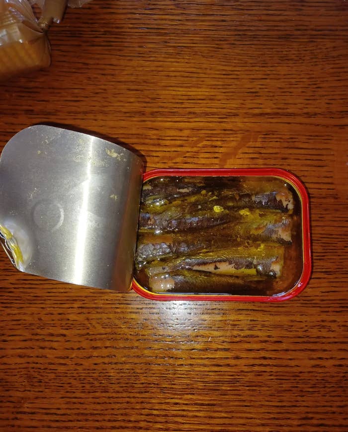 Screenshot of a Reddit post showing a can of sardines. The post discusses the feeling of opening the oldest can ever had