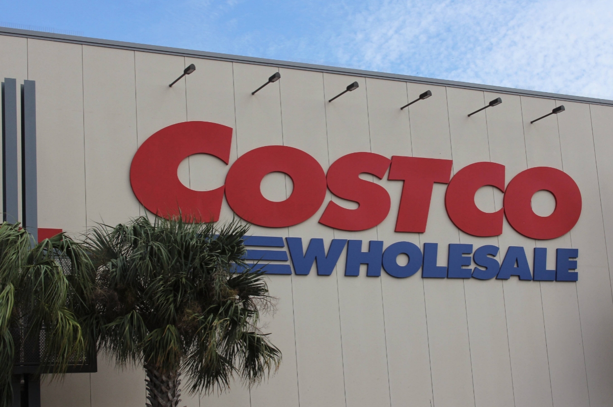 Costco Wholesale building exterior with palm trees nearby, featuring large red and blue logo signage