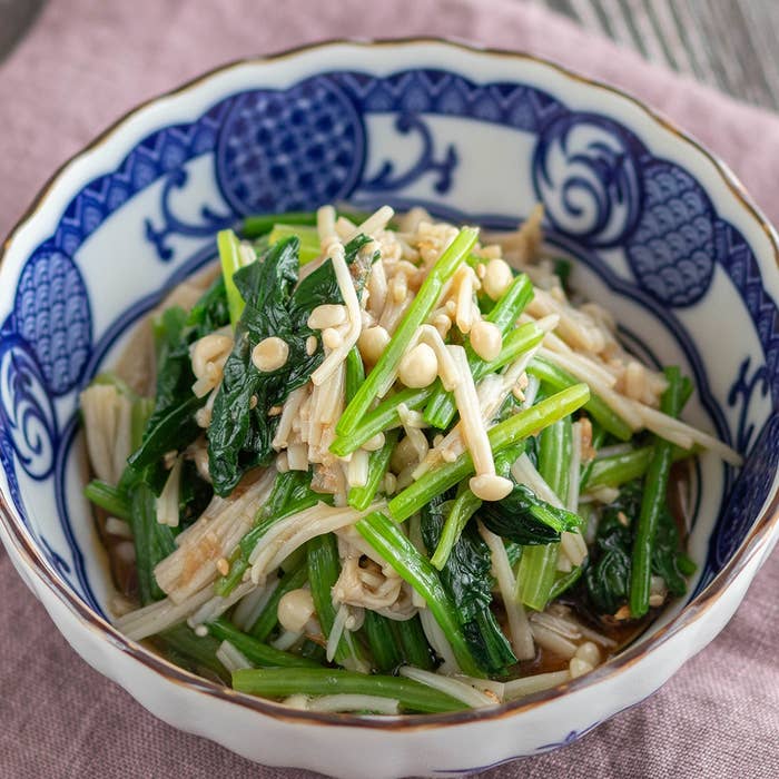 青い模様の皿に盛られたほうれん草とえのきの中華風和え物。