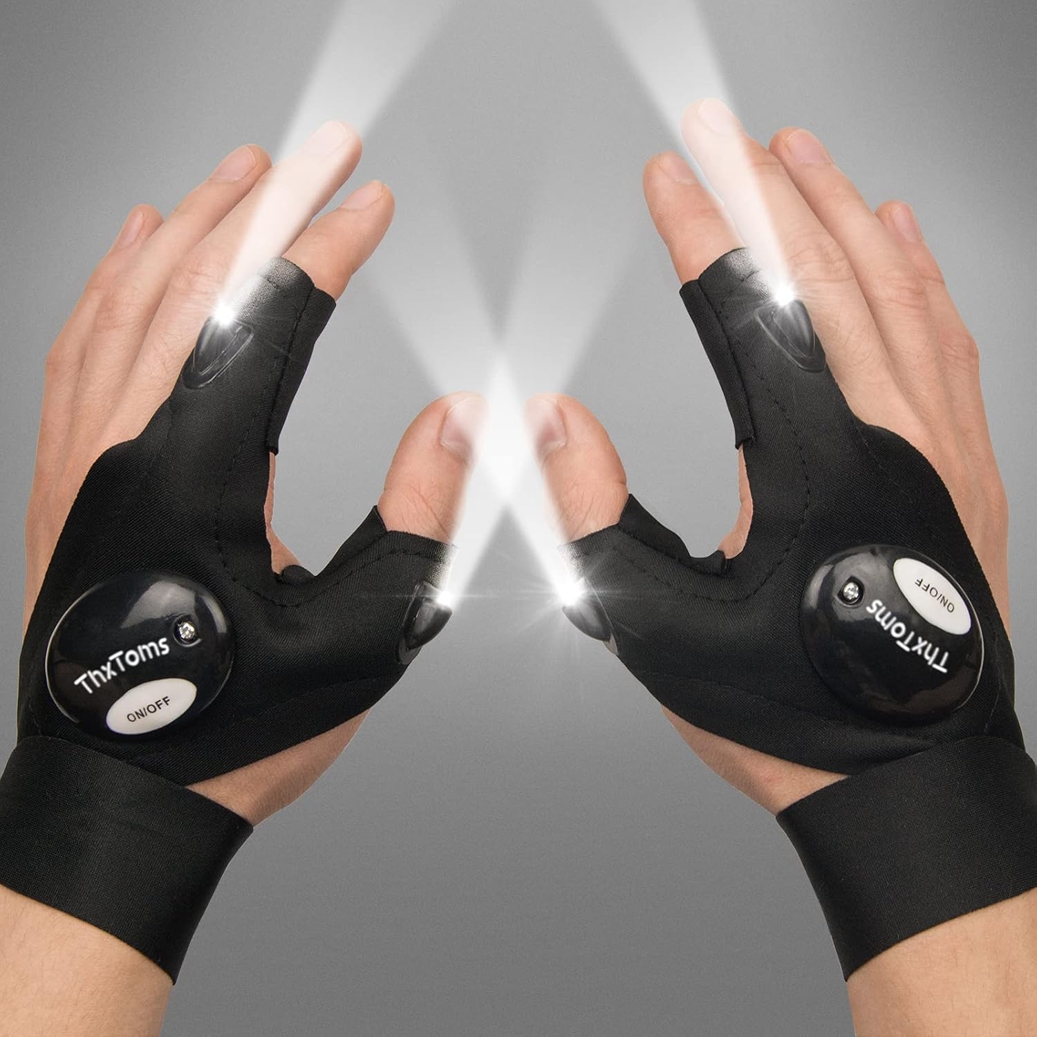 Hands wearing black, fingerless gloves with built-in LED lights shining from the fingertips