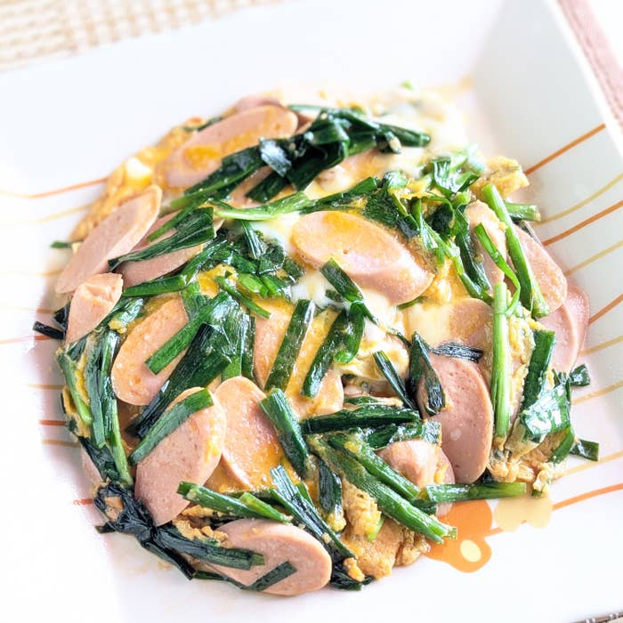 中国風オムレツが白いプレートに盛られている。ソーセージとニラが具材として載っている。