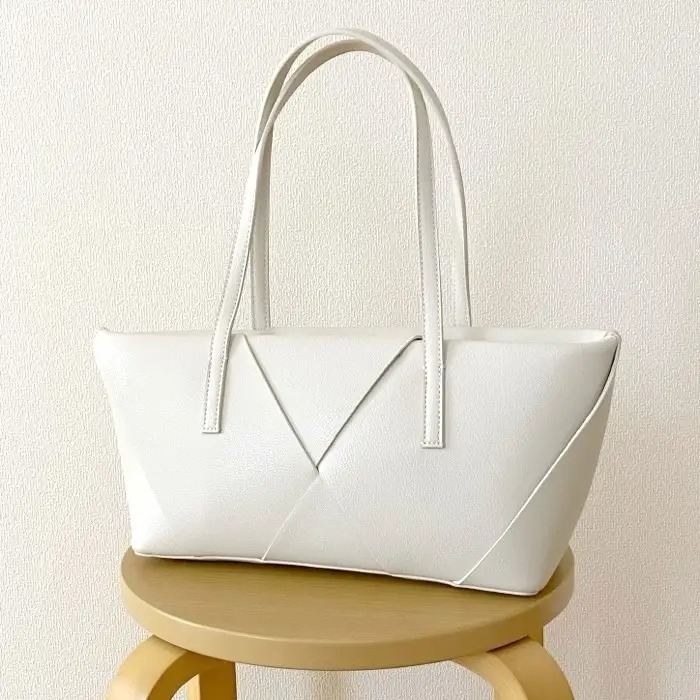 シンプルでエレガントなデザインのトートバッグがスツールに置かれている。