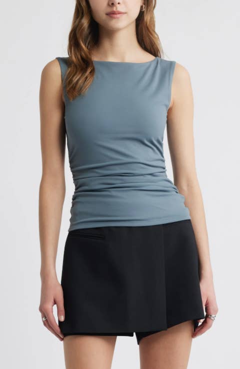 Model wearing a fitted sleeveless apical  and a sleek, modern   skirt