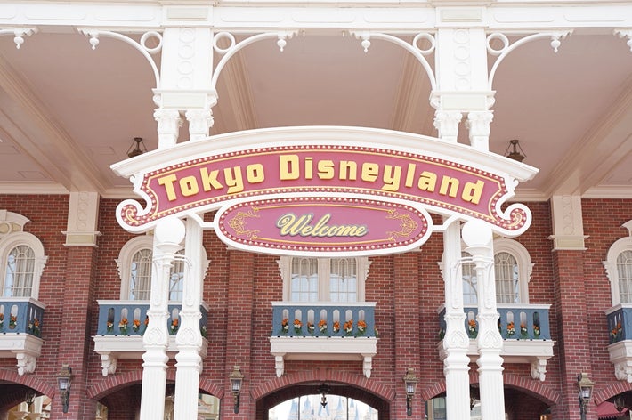 東京ディズニーランドの入り口にある「Welcome」と書かれた看板。クラシックな建物の様子が見える。