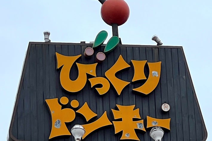 A large sign with stylized Japanese text and cartoonish eyes and feet