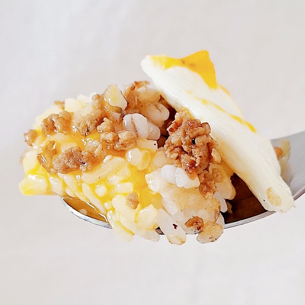 スプーンの上に、チーズがけのご飯とひき肉、卵が載っています。