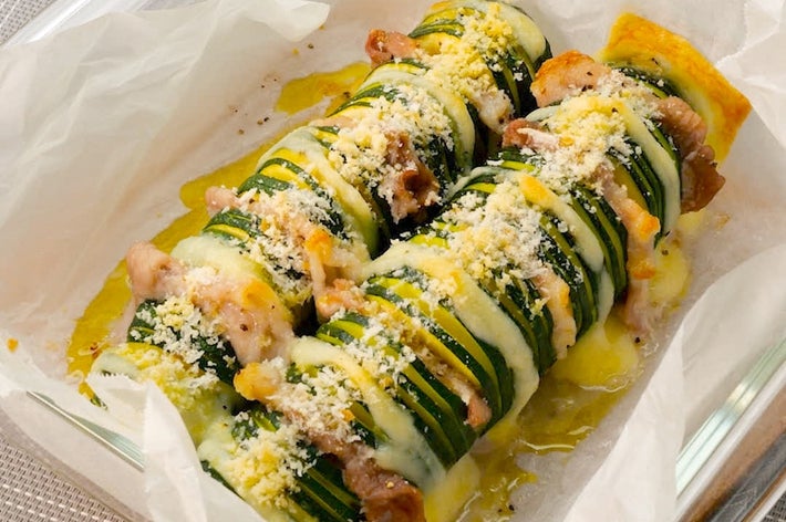 ズッキーニとベーコンがスライスされ、パン粉とチーズがトッピングされた焼き料理。