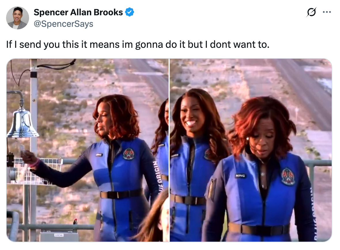 Two women in flight suits preparing for an outdoor activity; one looks hesitant, suggesting reluctance. Tweet overlay adds humorous context