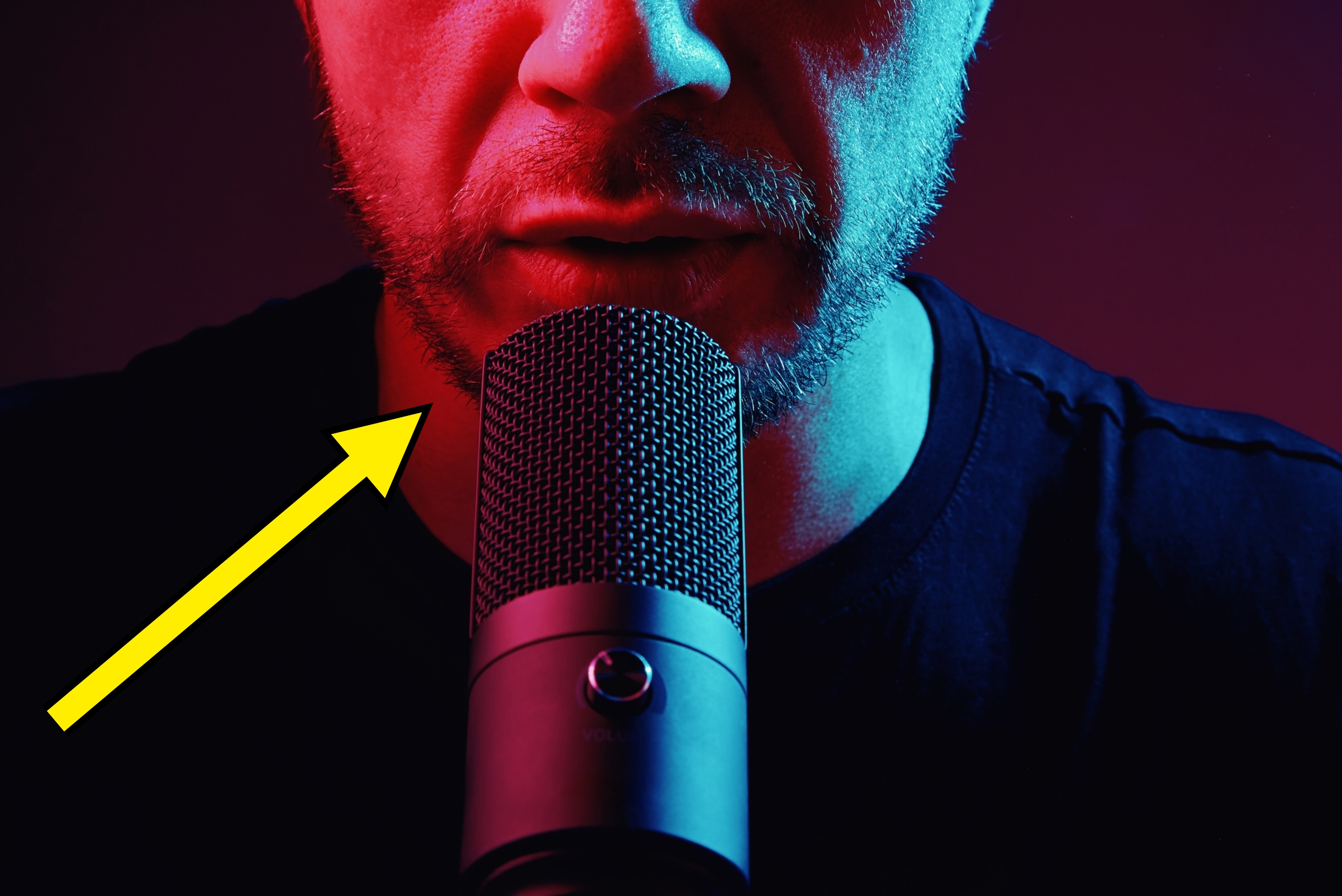 Close-up of a person speaking into a microphone, focusing on their mouth and the microphone, conveying a sense of speech or music performance