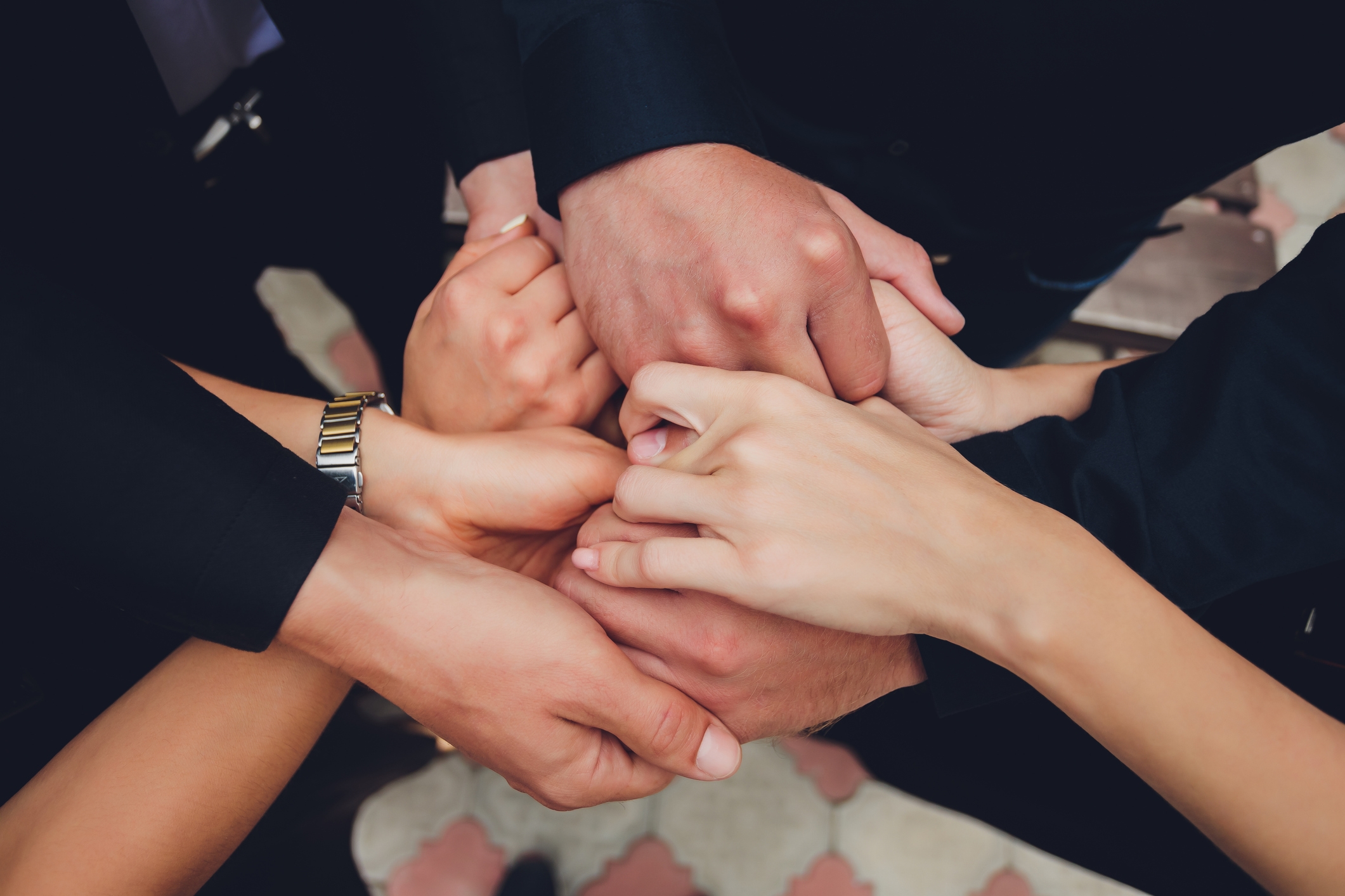 Hands of various people coming together in a supportive, unified gesture, symbolizing connection and togetherness in relationships