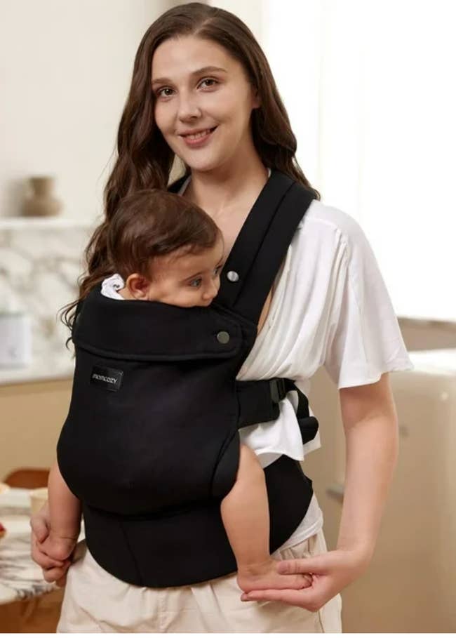 model successful a achromatic apical wearing a babe bearer with a babe inside, perfect for comfy and hands-free parenting