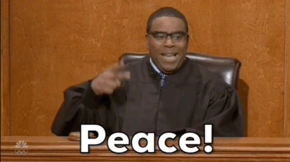 A person in a judge's robe laughing while showing a peace sign from behind a courtroom bench. The word "Peace!" is written below