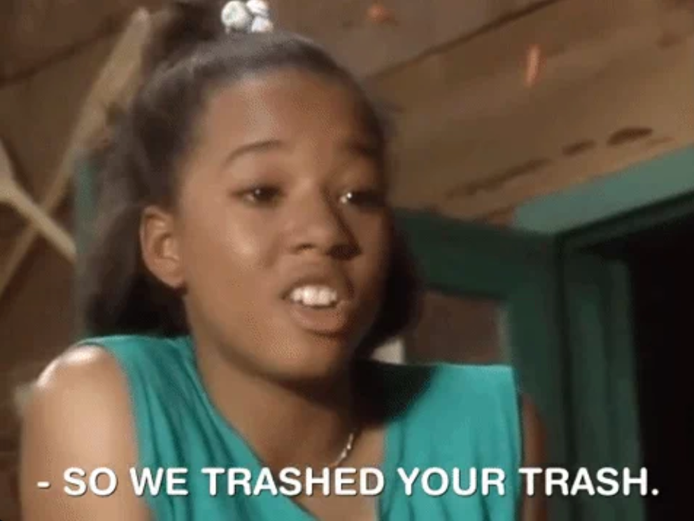 Person with a ponytail speaking with animated expression, caption reads "So we trashed your trash." Image from a scene in a media production
