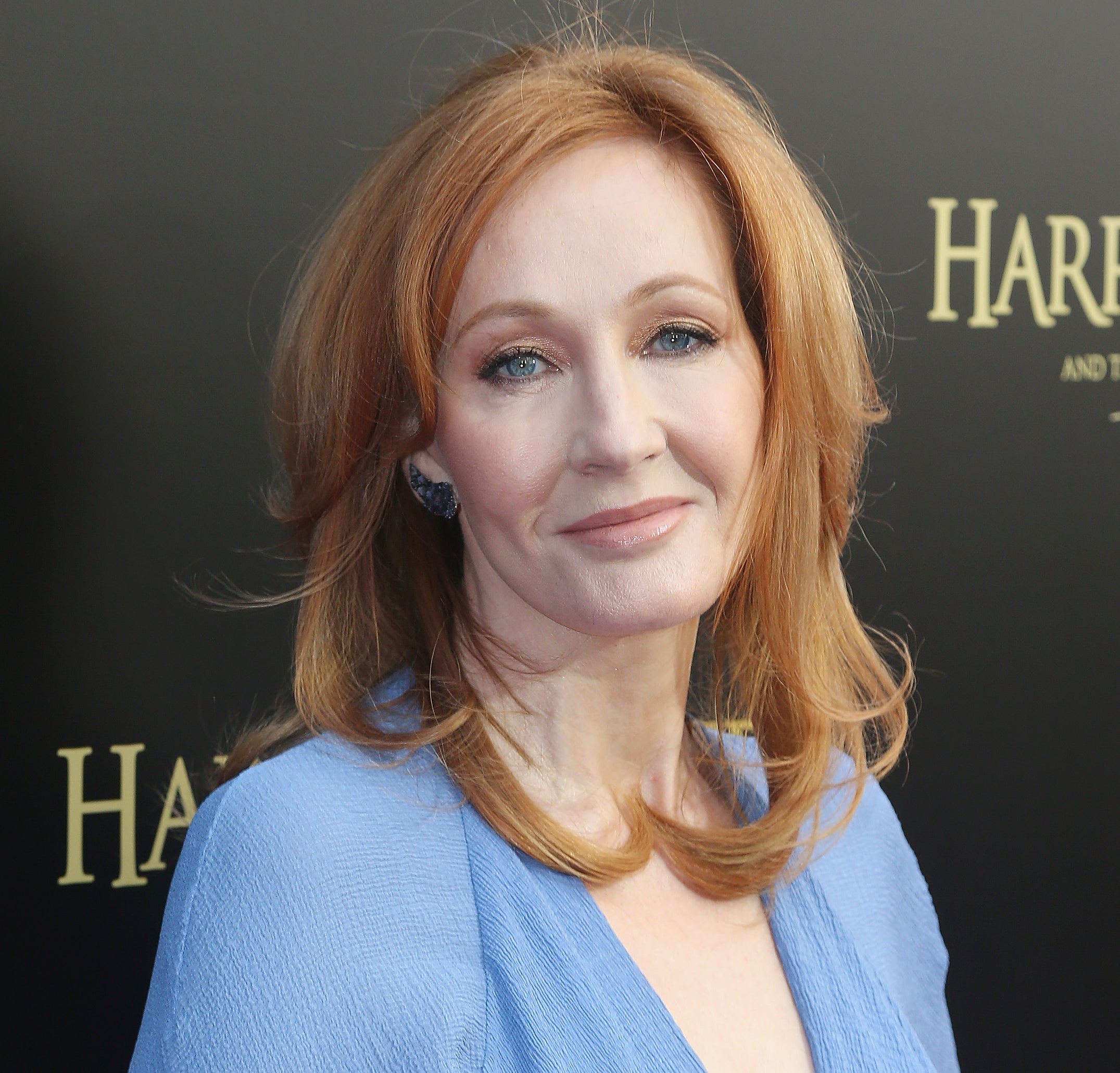 Person with long hair in a blue outfit at a 'Harry Potter and the Cursed Child' event