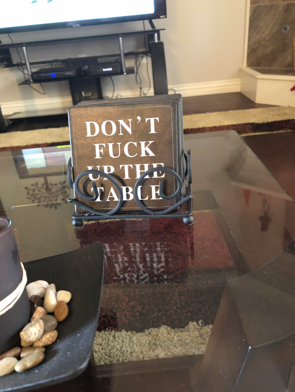 Coasters with humorous text: "Don't fuck up the table," displayed on a living room table