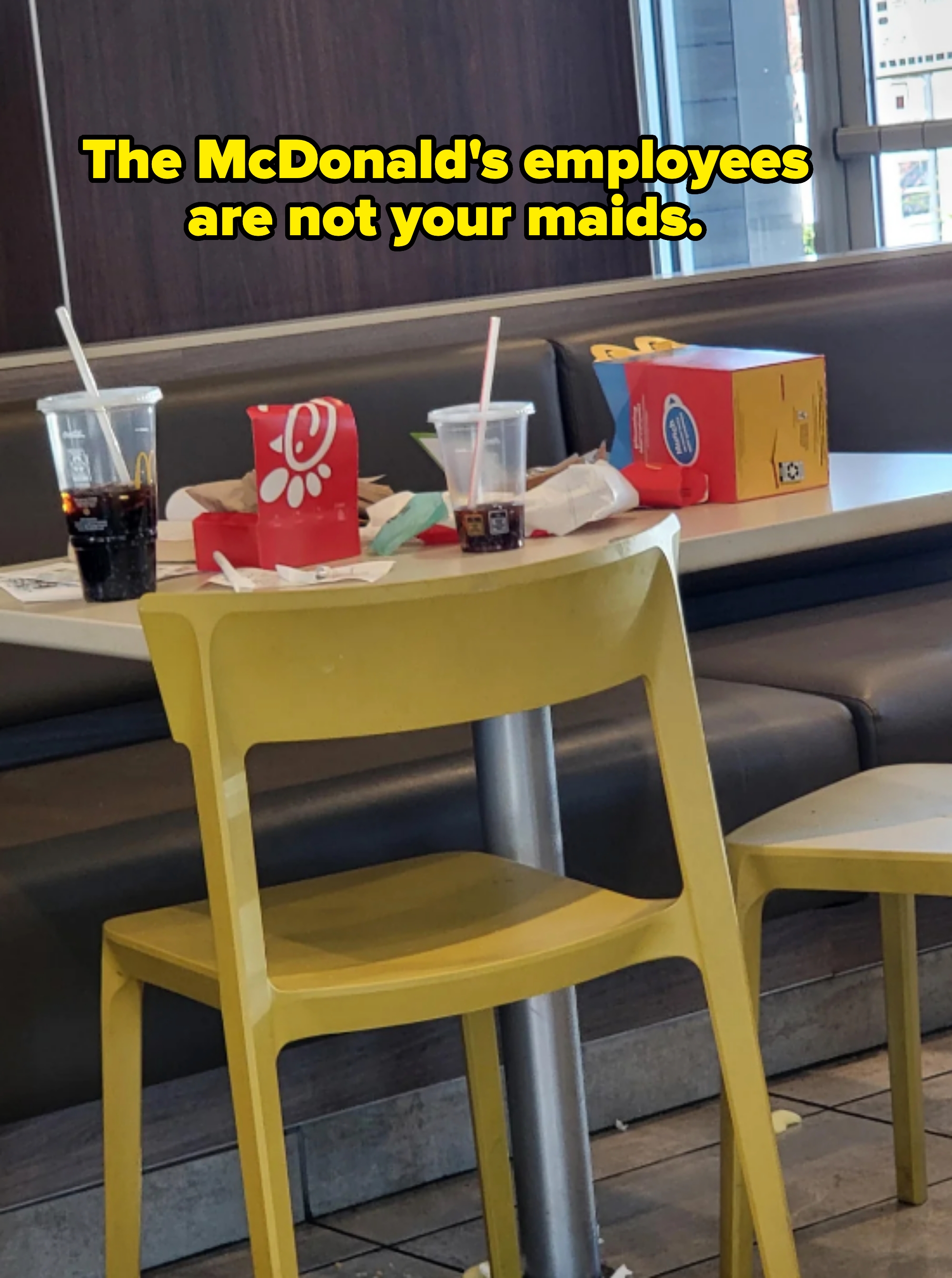 Fast food table with empty drink cups, two kids' meal boxes, and scattered napkins