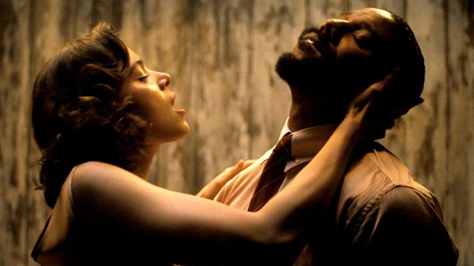 Escena dramática de una película: persona sostiene y mira a otra intensamente, creando un momento de tensión emocional