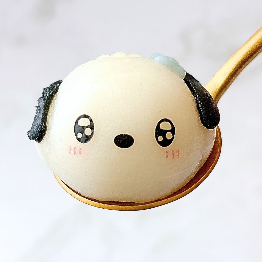 可愛い犬の形をした和菓子がスプーンにのっています。