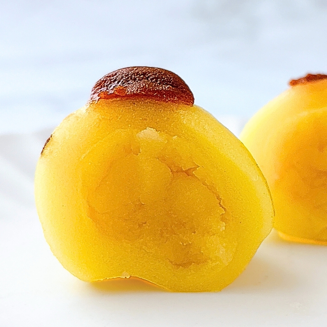 熟れた柿の断面が撮影された写真。柔らかさとジューシーさが際立っています。