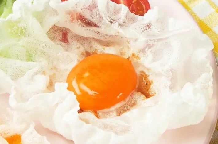 皿に盛られた目玉焼きがキャベツとミニトマトと一緒に置かれています。
