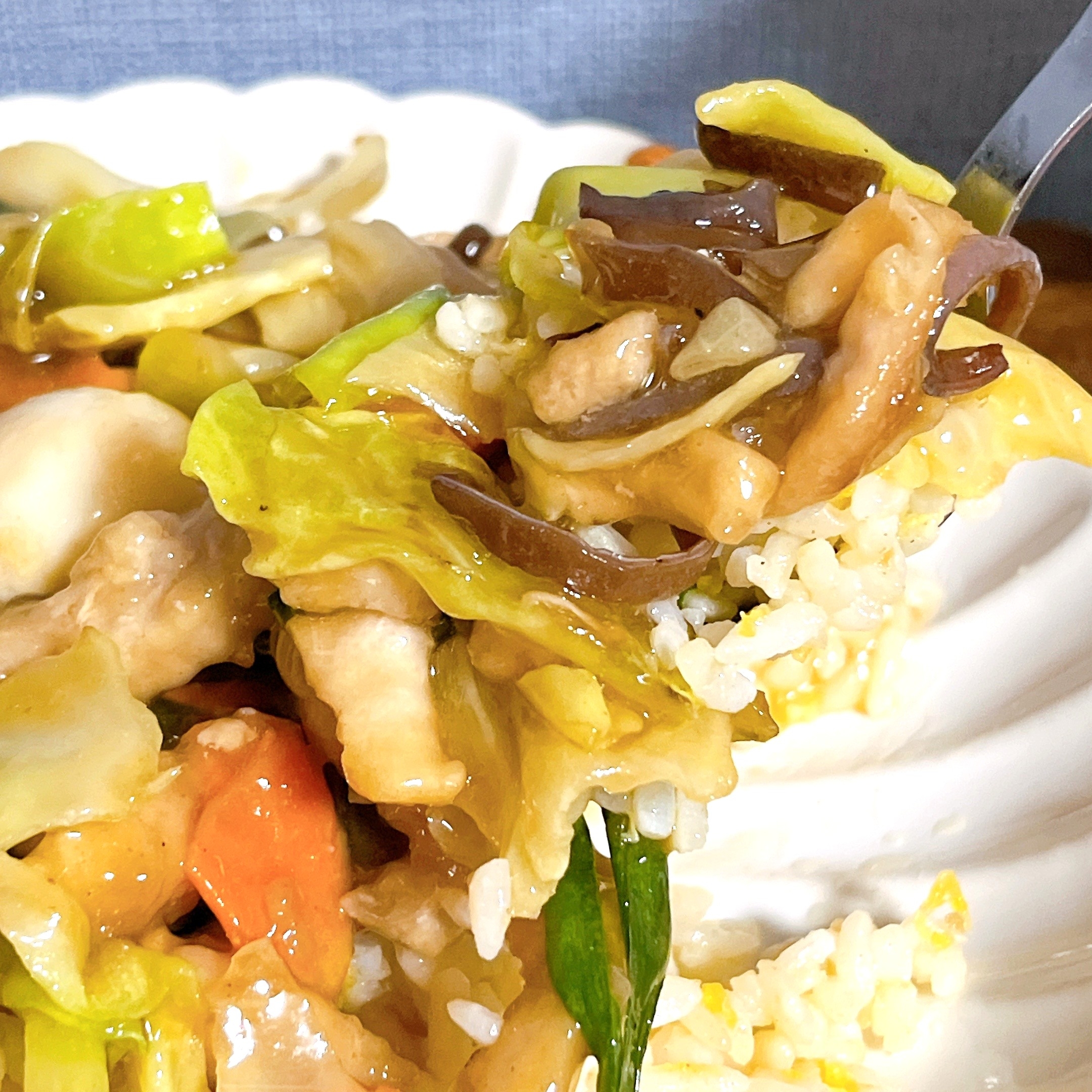 中華風の野菜炒めがライスの上に盛られた料理のクローズアップ。