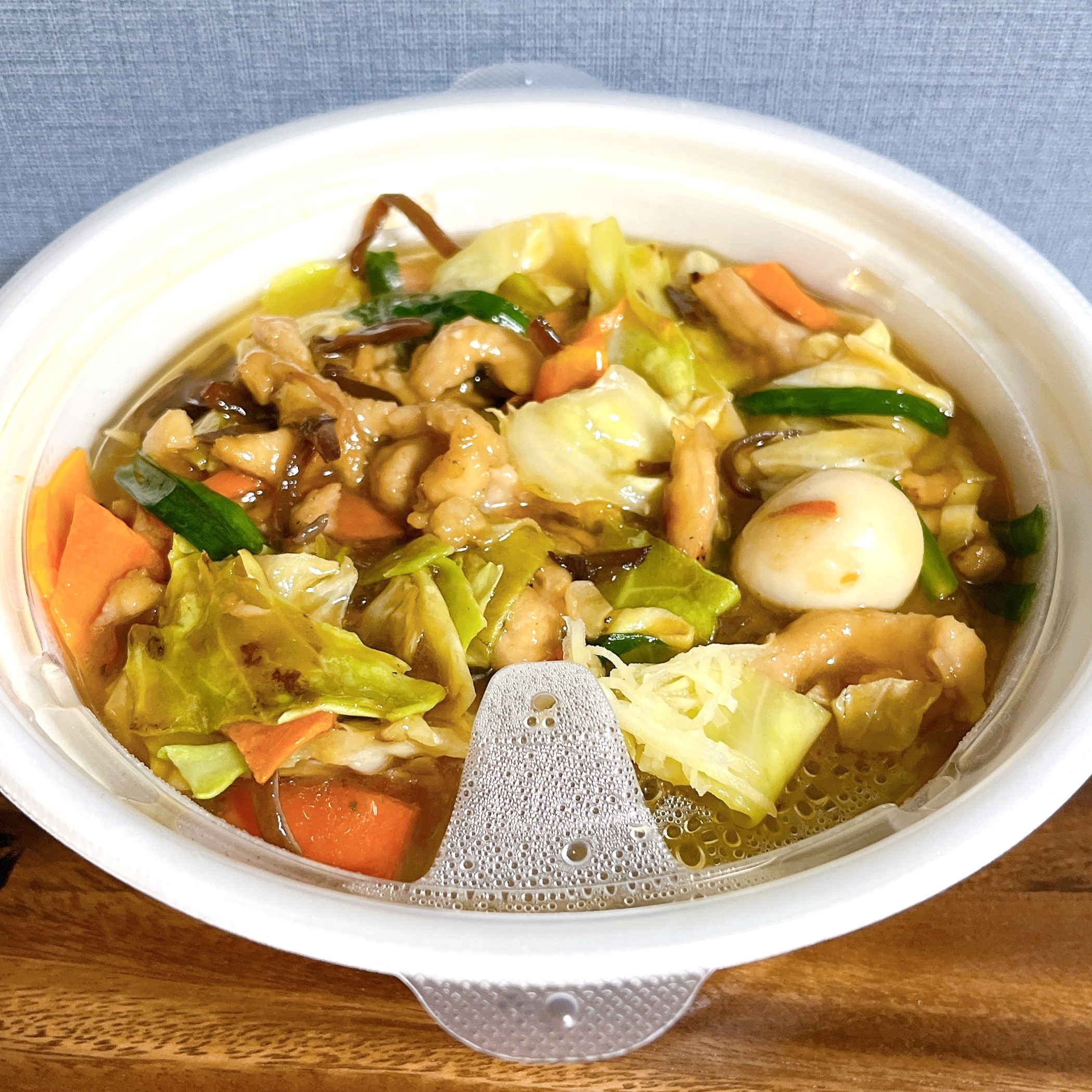 中華料理の丼に、鶏肉、野菜、うずらの卵が盛り付けられています。