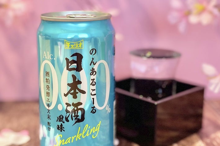 ノンアルコールスパークリング日本酒の缶と木箱に入ったグラス。背景に桜の花が飾られている。