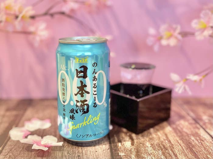 桜の背景にある日本酒スパークリング缶と升に入った和風の飲み物。