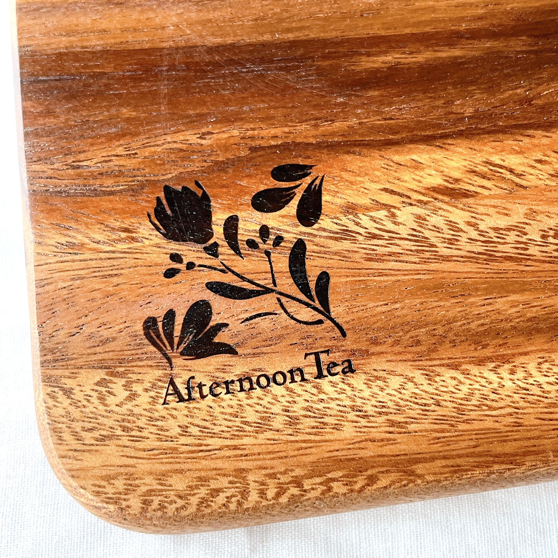 木製のプレートに「Afternoon Tea」と植物のイラストが刻印されています。