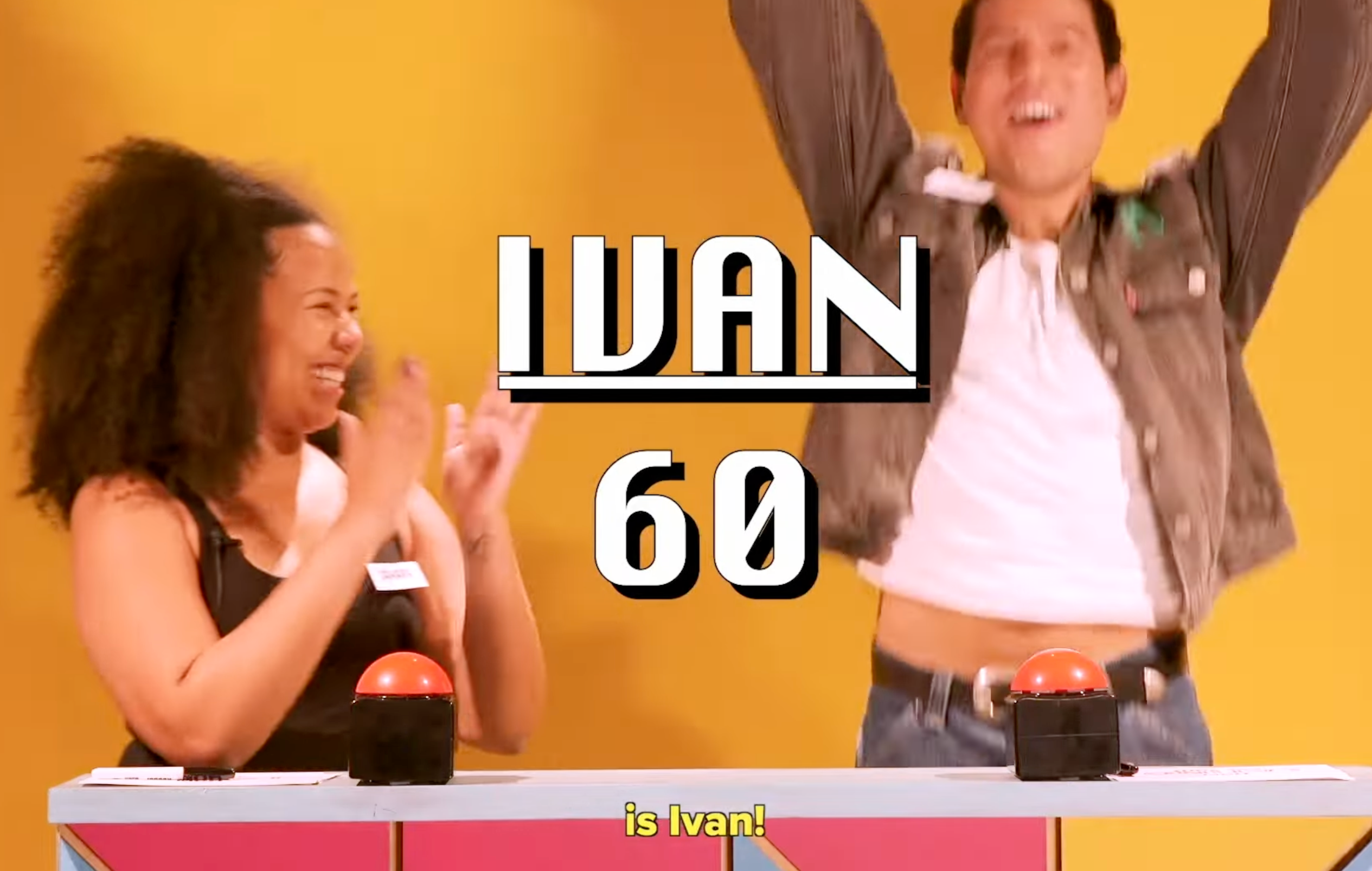 Two people celebrating at a game show with the name "Ivan" and number "60" on screen. One wears a jacket, the other claps