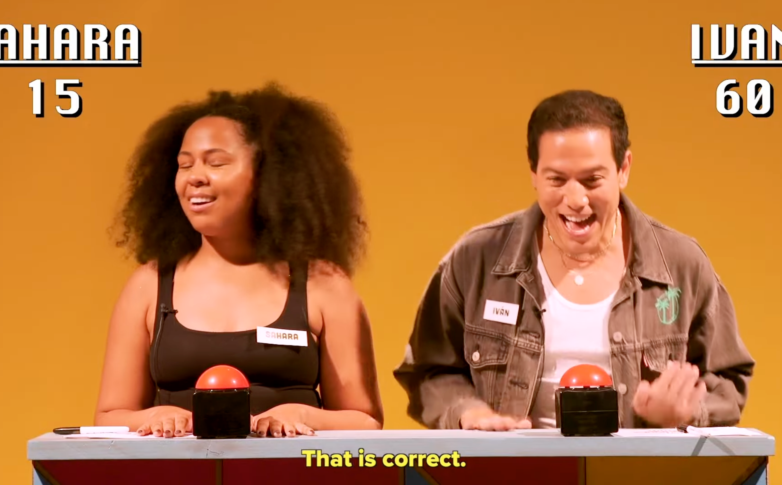 Two people playing a quiz game show; one with 15 points, the other with 60. Host says, "That is correct."