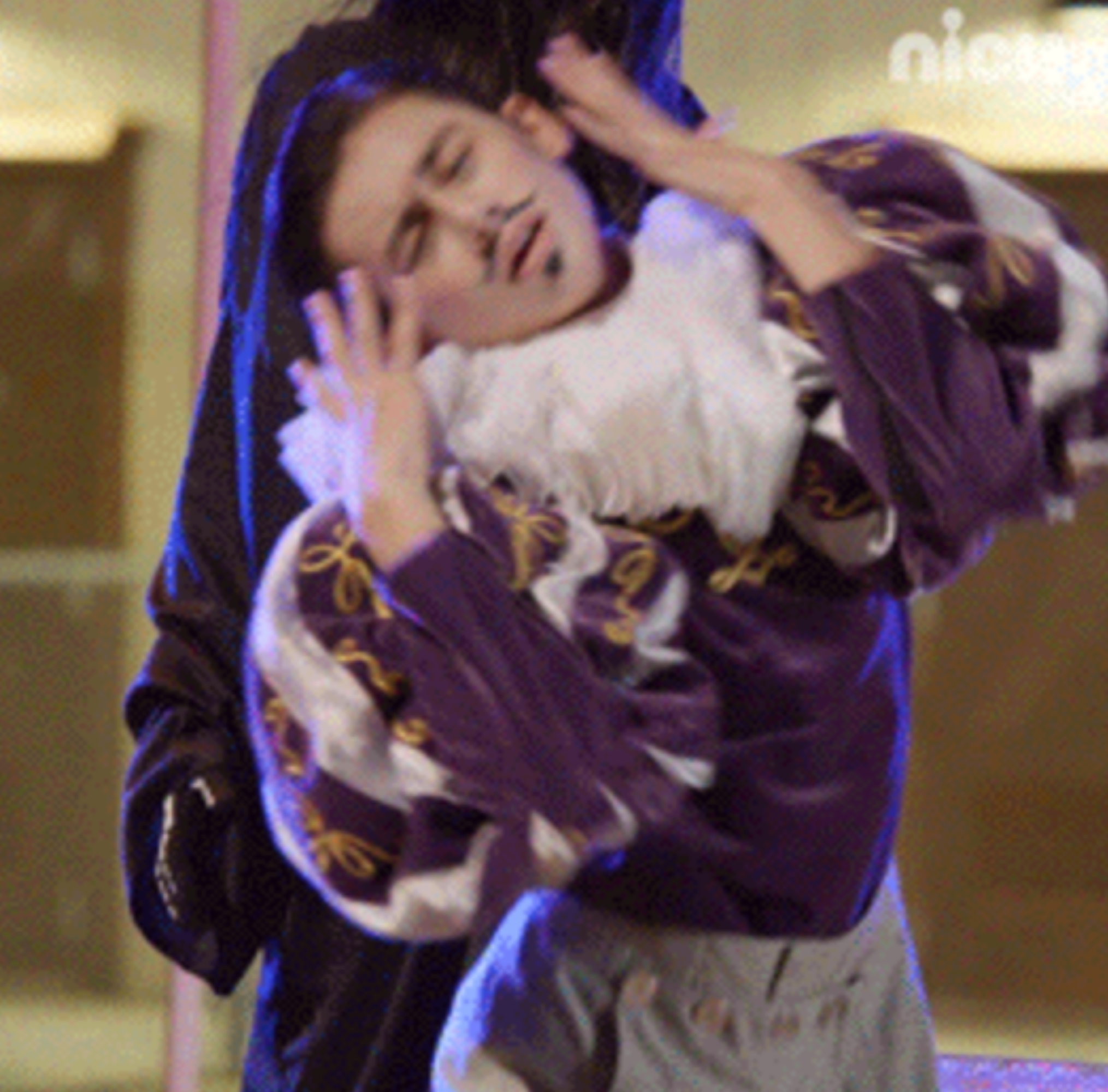 Person dramatically posing in theatrical outfit with exaggerated gestures, wearing a ruffled collar and patterned sleeves