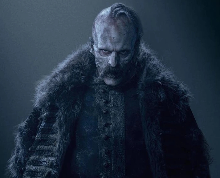 Persona caracterizada como un personaje oscuro y amenazante, con chaqueta de piel y expresión intensa