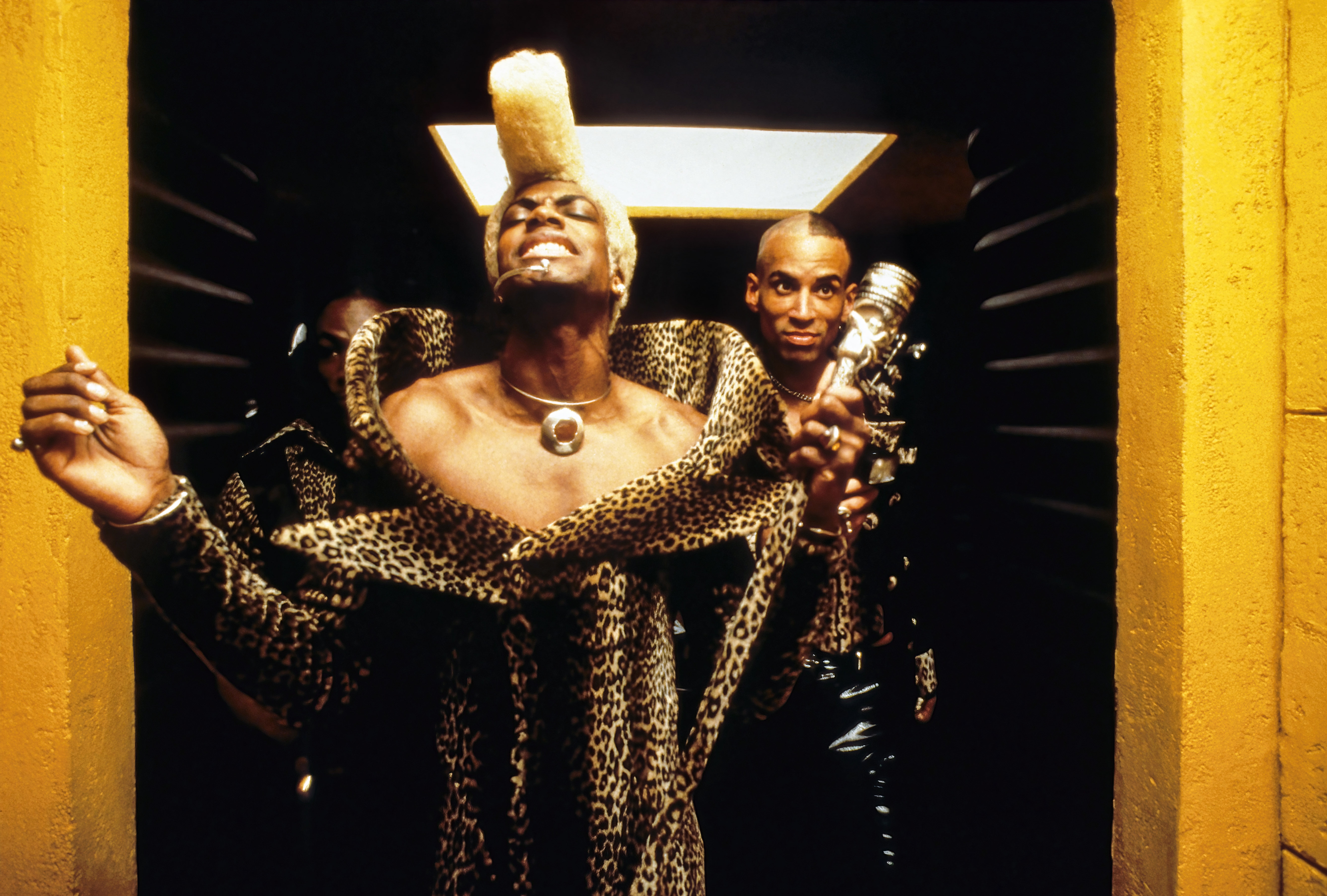 Chris Tucker as Ruby Rhid posing confidently in a corridor