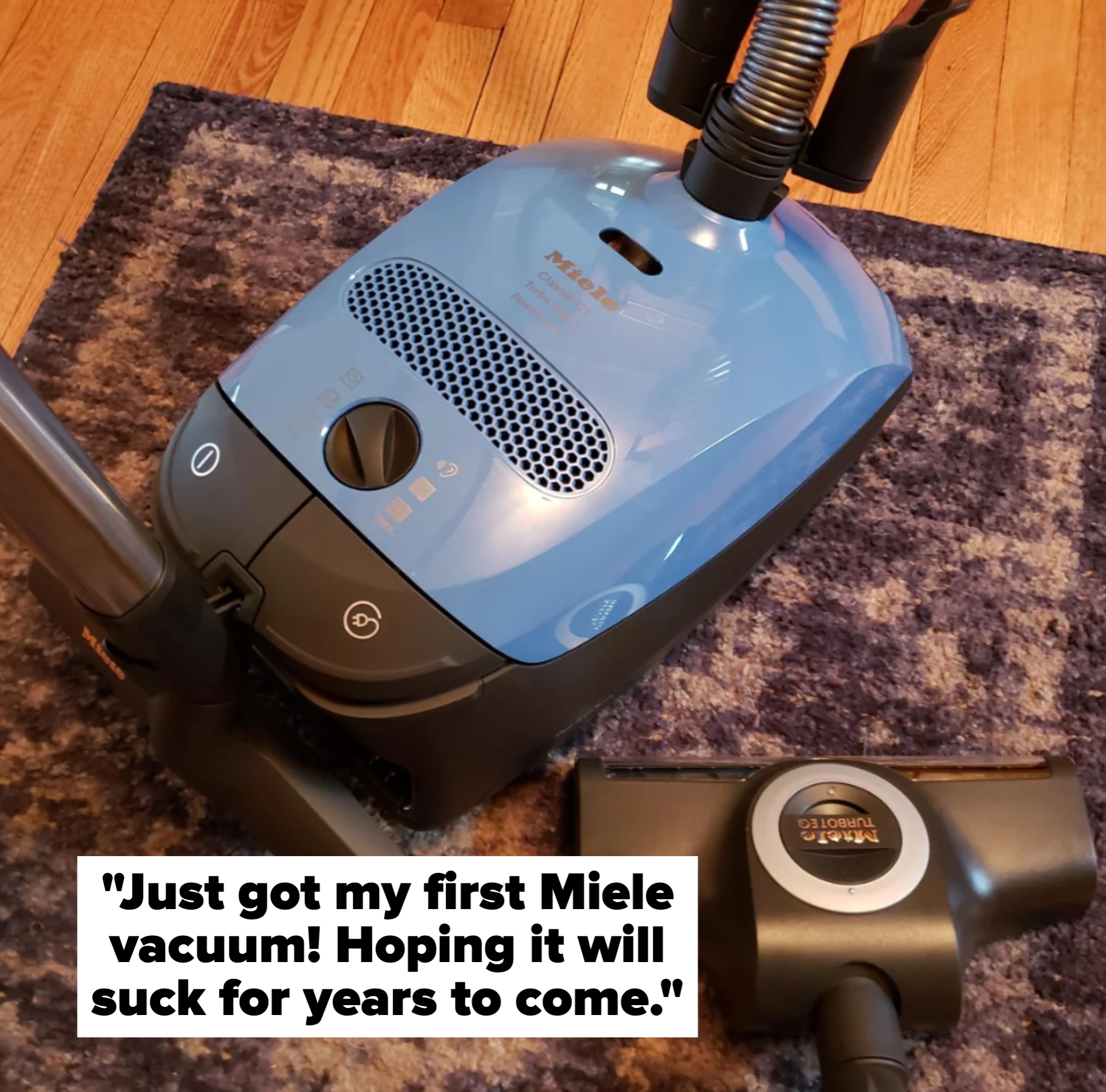 Vacuum cleaner on a carpeted floor, with detachable nozzle placed beside it