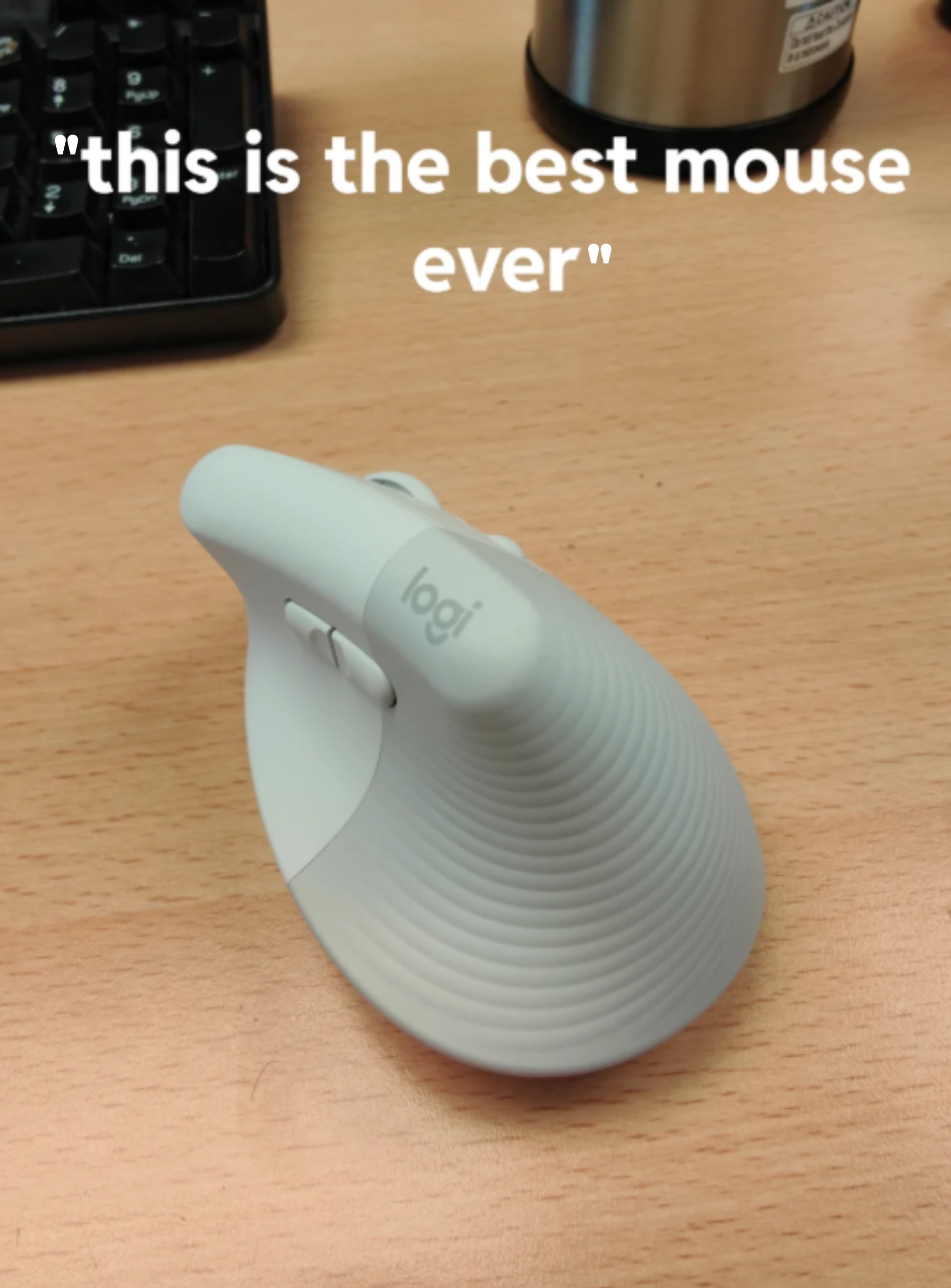 Ergonomic vertical computer mouse on a desk with text saying "this is the best mouse ever."